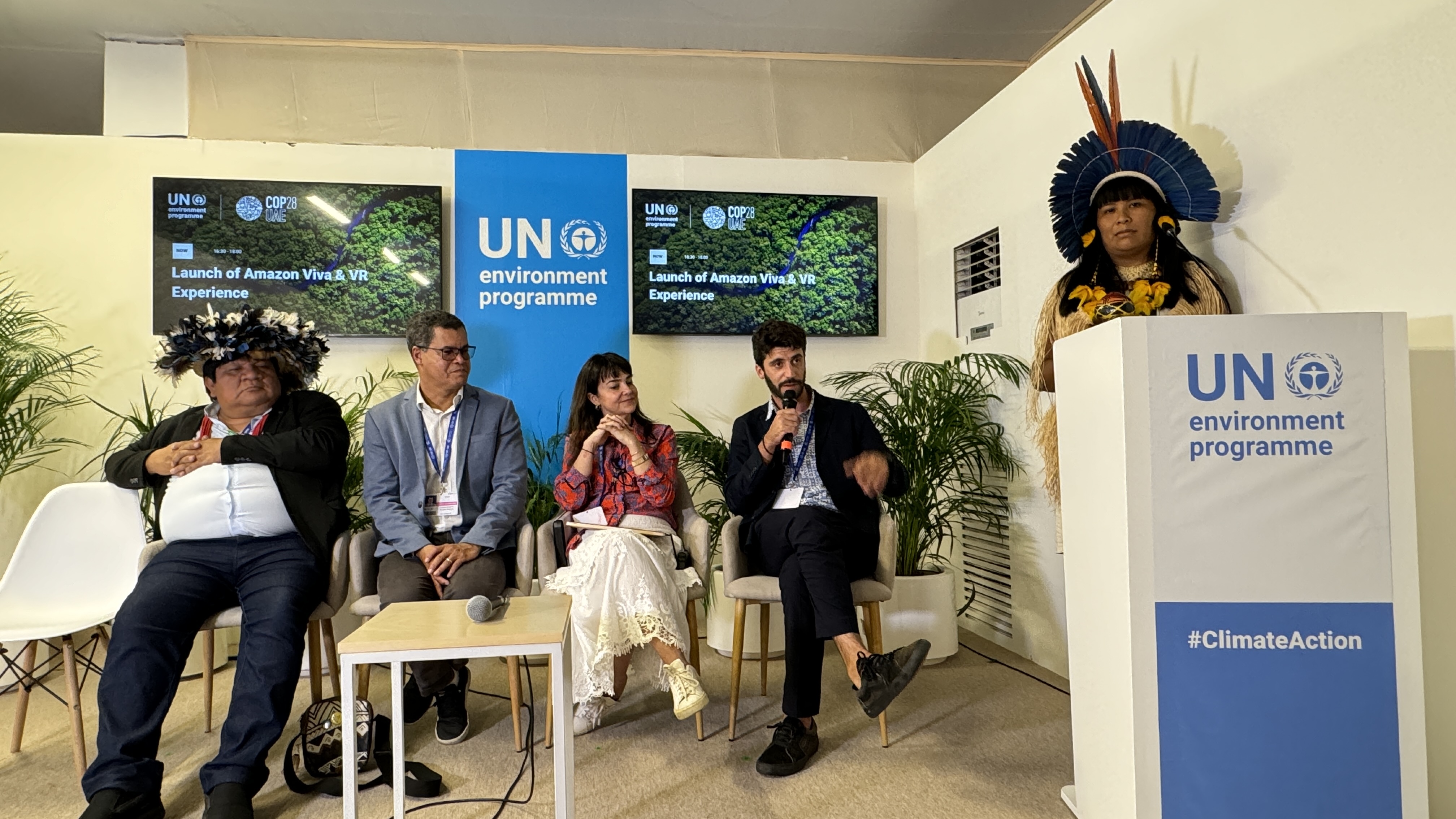 Panelists engaging in a discussion, female panelist dressed in traditional indigenous clothing