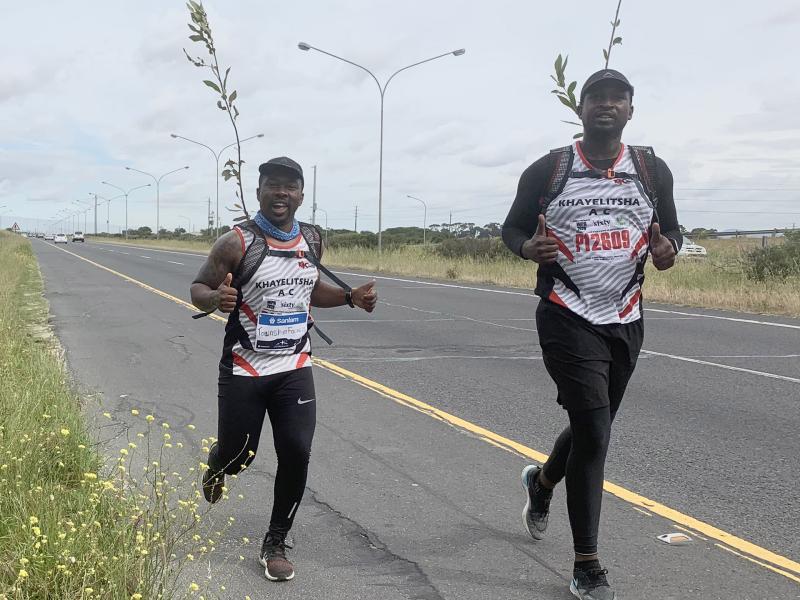 Siya running with a tree on his back